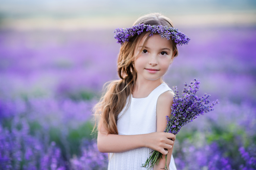 Beautiful girl in a field of lavender on sunset. Girl in amazing dress walk on the lavender field.